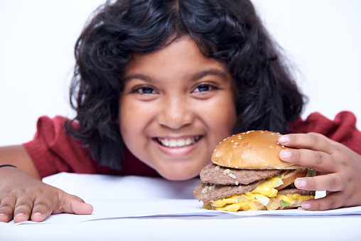 A little girl with an appetizing burger, Close-up focus on Burger