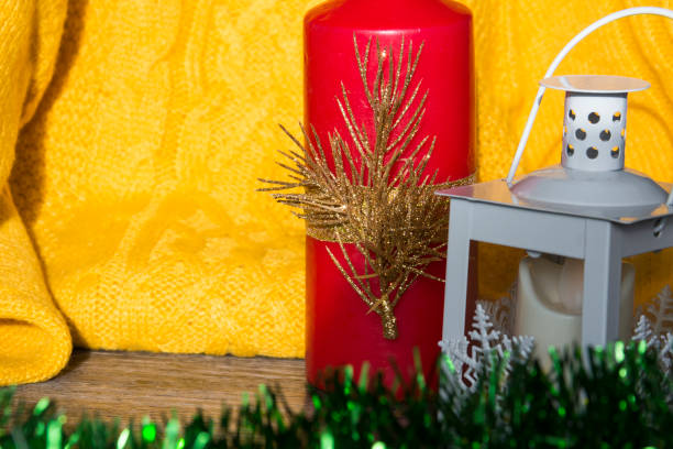 Christmas decorations and decorations with a yellow sweater and a red candle on a wooden surface.