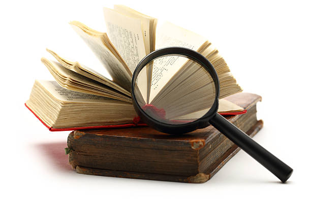 istock Magnifying glass and old books 173664948