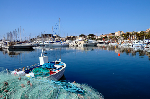 Marina of Bandol in France. View of fishing nets, boats and provencal village of Bandol.
