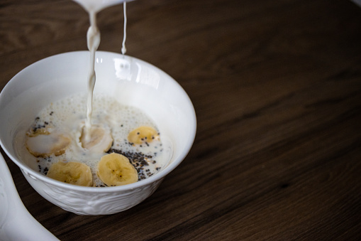 bananas, milk and muesli on a wooden table