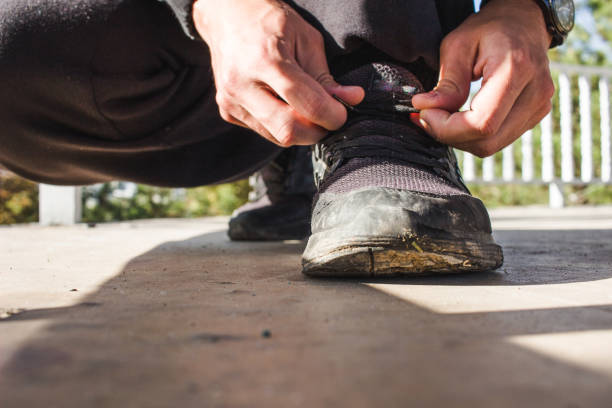 istock Young adult guy tying shoes for exercise concept 1736660351