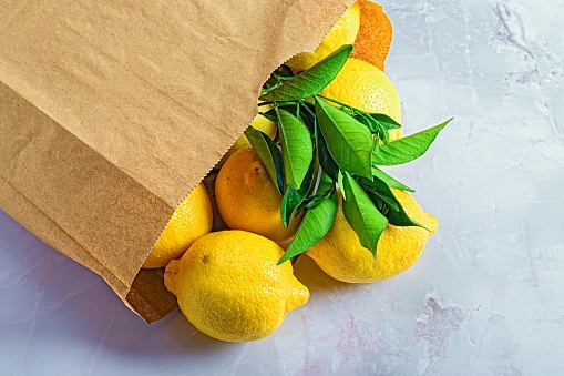 A closeup shot of a package of yellow lemons on a marble table
