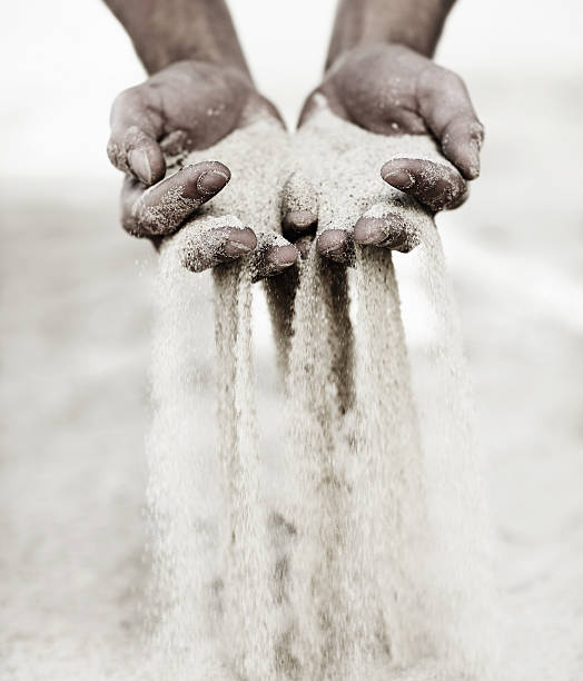 momentos antideslizante a través de las manos, como granos de arena. - sifting fotografías e imágenes de stock