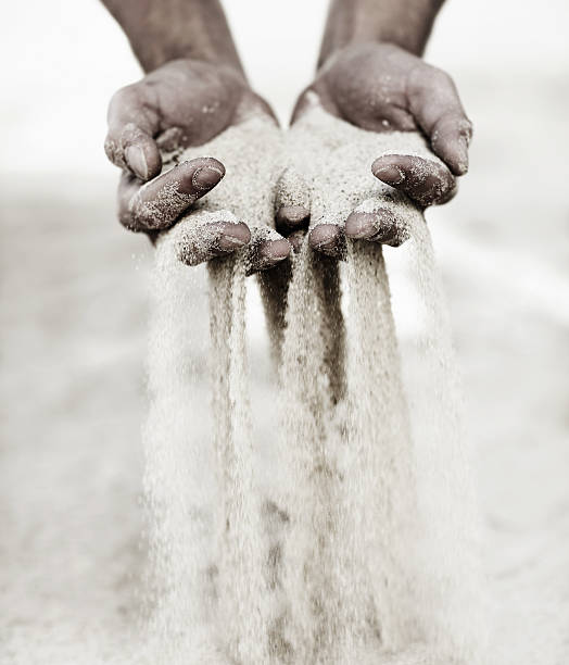 Moments slip through his hands like grains of sand... Two hands holding up sand black and white beach stock pictures, royalty-free photos & images