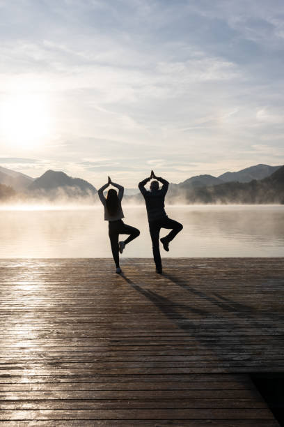 istock Father and daughter doing yoga by a lake 1736688372