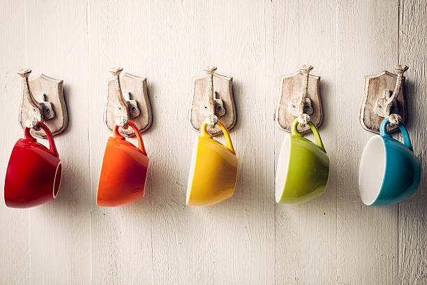 Colorful coffee cups on hooks Colorful coffee cups on hooks coat hook photos stock pictures, royalty-free photos & images