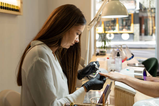 istock Worker painting patiently the nails of a client 1736714860