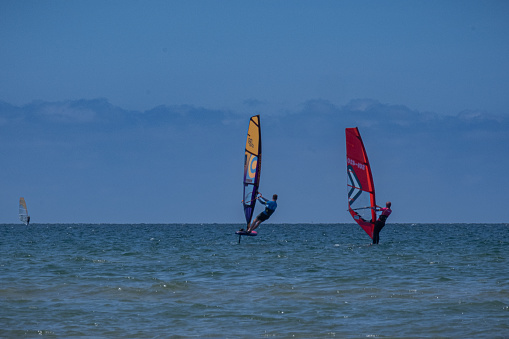 Sunset sky over the Indian Ocean bay with a kiteboarder riding kiteboard with a green bright power kite. Active sport people and beauty in Nature concept image. Le Morne beach, Mauritius.