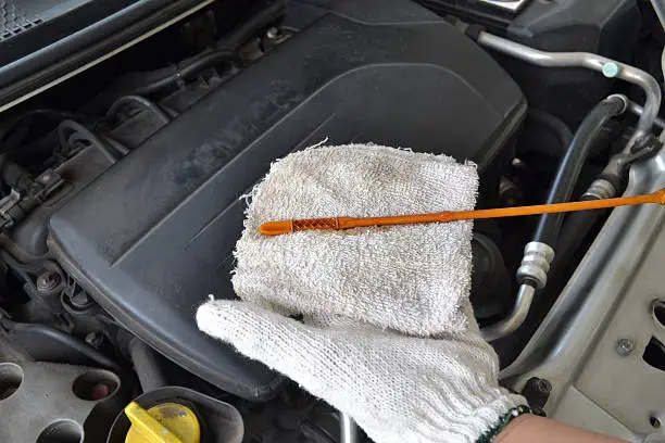 Carmechanicchecking the oil of a car