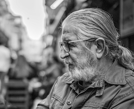 Black and white portrait of old man with long hair