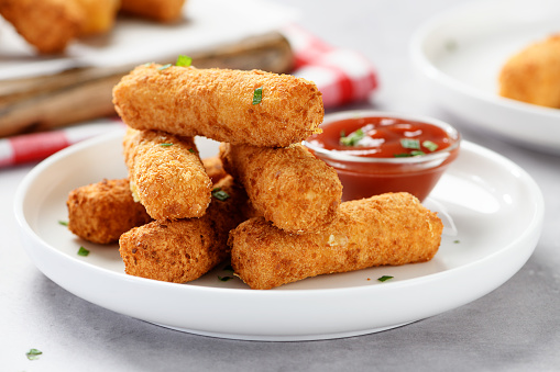 Breaded fried mozzarella cheese sticks with tomato dipping sauce.