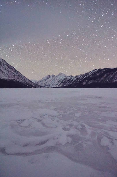 istock Frozen lake in the mountains at night with a clear starry sky. 1736727702