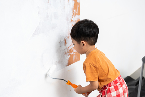 child Asian boy Paint yourself house's walls.