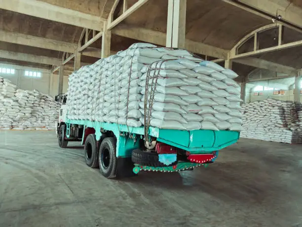 Truck laden with bags white sacks in a warehouse godown factory stocks supply  camion charge de sacs image photo.