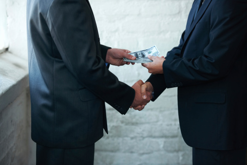 Two corporate businessmen shaking hands and making a financial deal