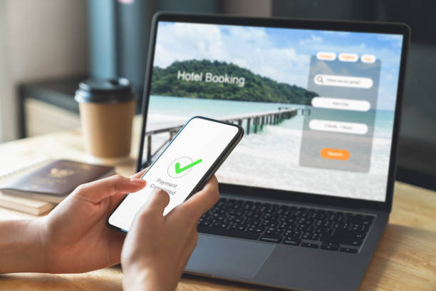 istock Hand using laptop and booking hotel on website for vacation after a long work and payment completed message on mobile, Summer holiday concept. 1736756910