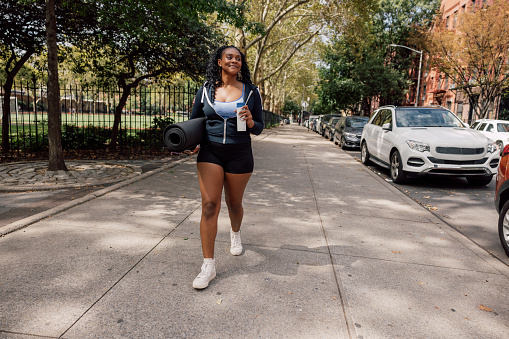 Healthy woman walking in New York going to the park for a outdoors training class.