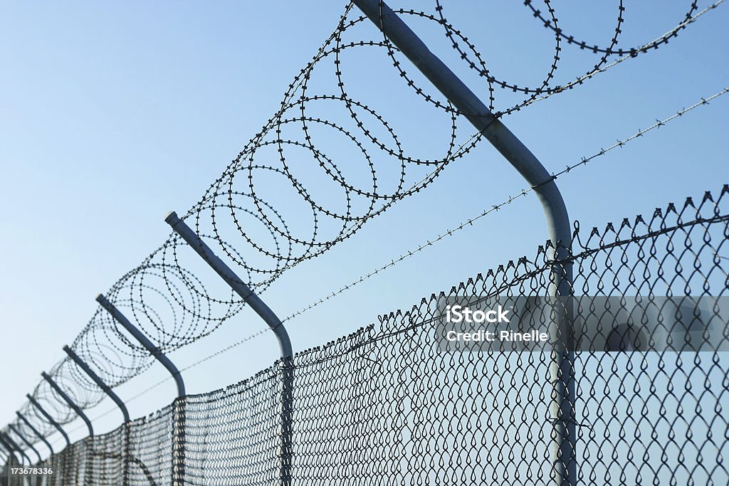 Keep Out "A chain link fence, topped by razor wire." Adversity Stock Photo