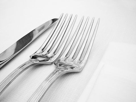 silver forks and knife on white linen cloth
