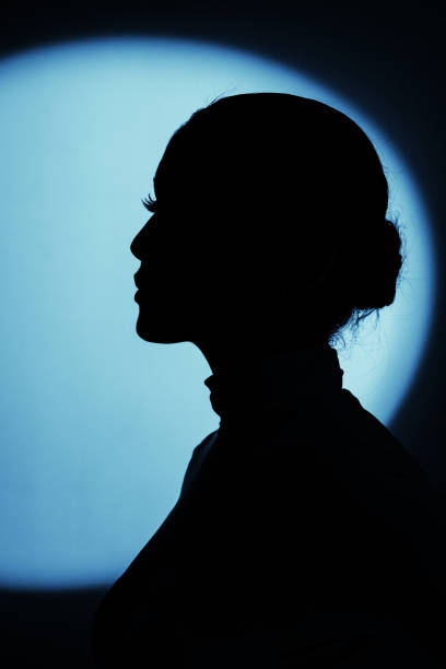istock Woman profile black silhouette portrait in blue illuminated round light background 1736791438