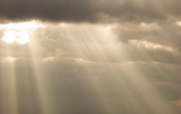 sunburst through clouds stock photo