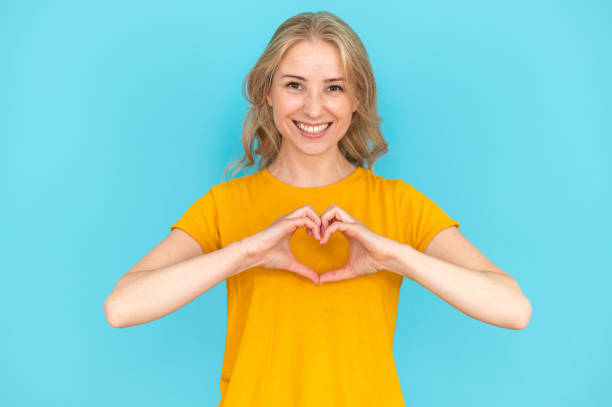 mujer mostrando forma de corazón, símbolo de amor - artificial true exam blue fotografías e imágenes de stock
