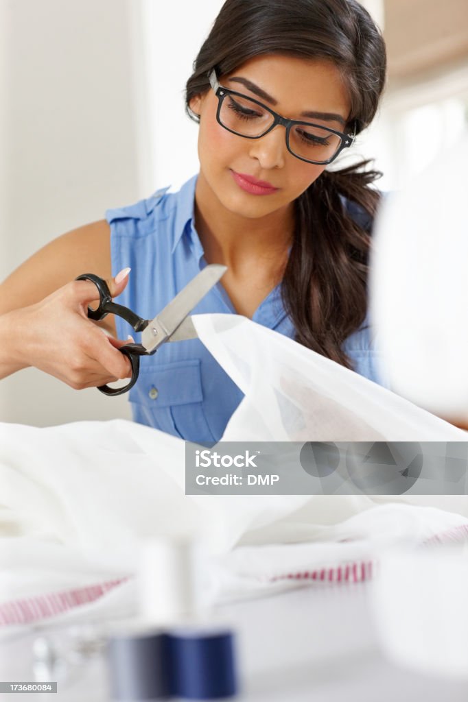 Hermoso dressmaker Cortar una pieza de material blanco - Foto de stock de 20 a 29 años libre de derechos