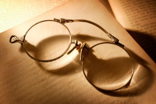 Antique eyeglasses sitting on old book