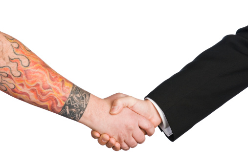 Contrasting business handshake. Blue collar and white collar business working together.