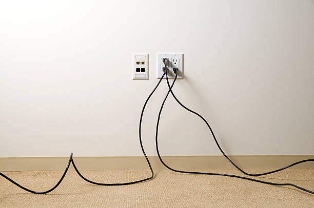Plugged In Electrical extensions chords plugged into wall in an office space. chord stock pictures, royalty-free photos & images