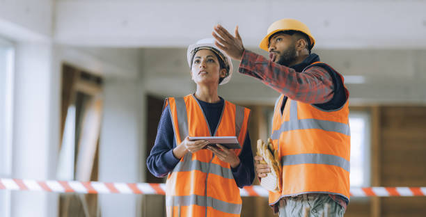 Architects examining construction site while using a digital tablet stock photo