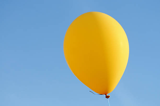 istock yellow balloon floating in the blue sky 173683228