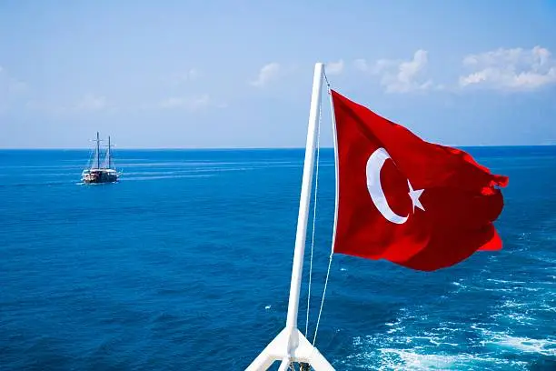 Turkish flag on the ship flagpole and sailer. Turkey. Mediterranean Sea. High seas.