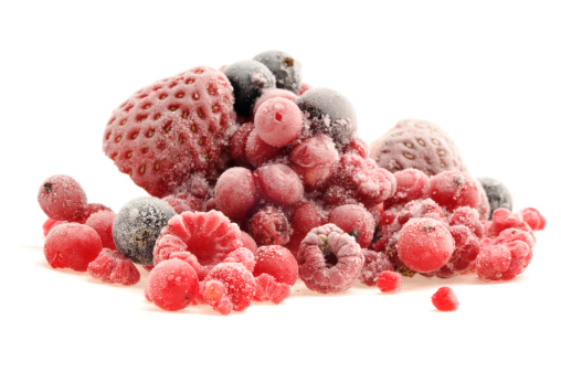 Frozen summer fruits isolated on white.