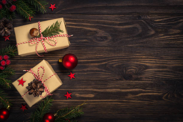 istock Christmas background with fir tree, present box and decorations at wooden table. 1736854883
