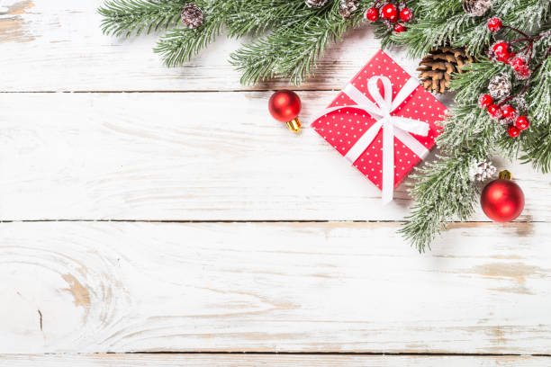 istock Winter fir tree with snow and decorations at white table. 1736856201