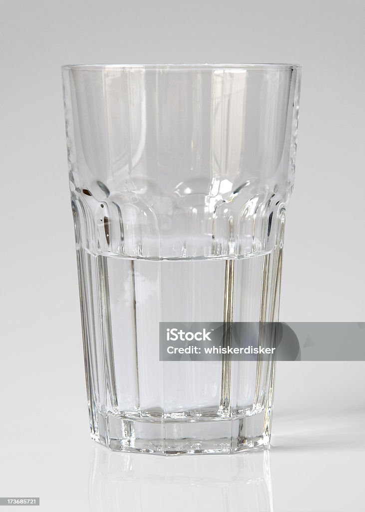 Glass half empty or full? Contains clipping path "A glass of water, half full or half empty. Contains a clipping path for use as an object" Clean Stock Photo