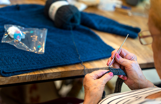 Crochet Club. Elderly woman knitting. The art of tradition.