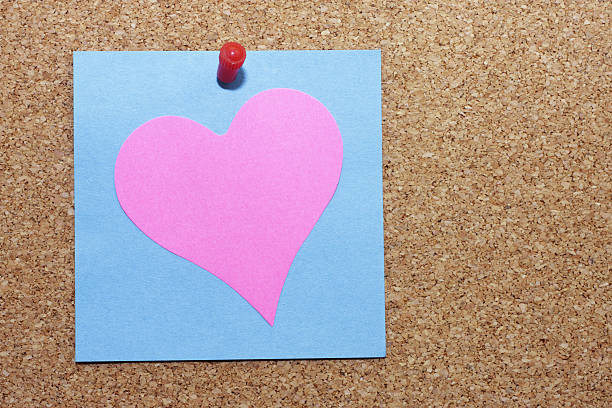 istock Pink Valentine's heart pinned with blue Post-It stickie notelet 173689031