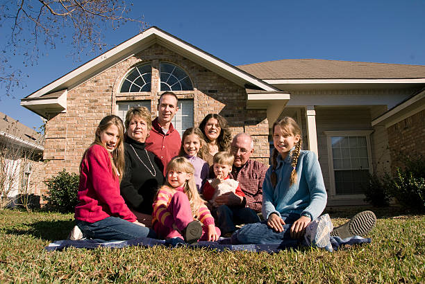 istock Multi-generational family sitting on front lawn 173689383