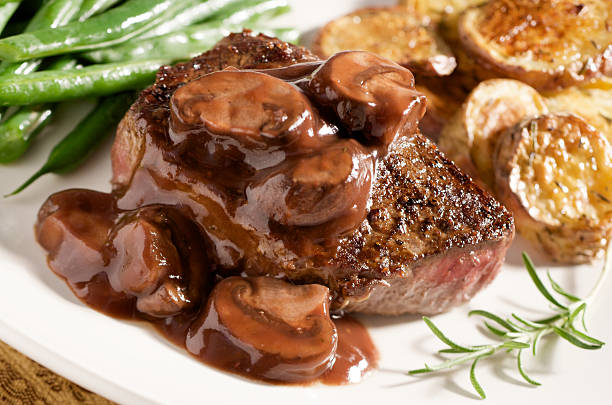 Steak with Mushroom Wine Sauce and Vegetables "Juicy steak with a ruby port wine mushroom sauce, roasted potatoes, and green beans." savoury sauce stock pictures, royalty-free photos & images