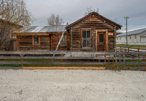 Dawson City, Yukon, Canada – October 05, 2023:  Historic 1904 log cabin on a city street