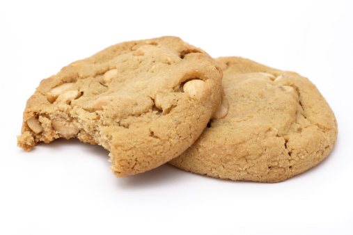 two peanut butter cookies,one with bite missing,isolated on white