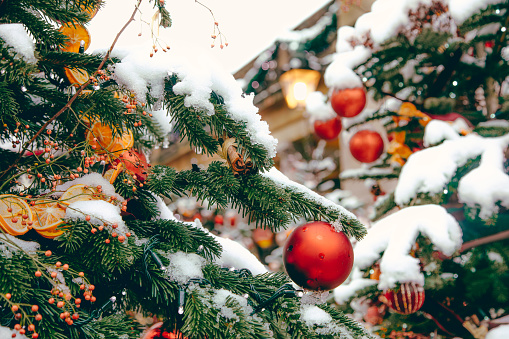 Detail of colorful and illuminated Christmas trees on snowy London streets during a festive Christmas day. This image captures the fresh snow-covered holiday atmosphere