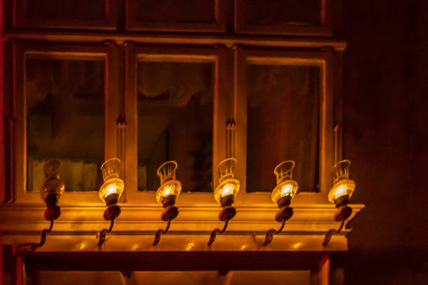 Glowing lantern illuminates old-fashioned balcony decoration with candles.
