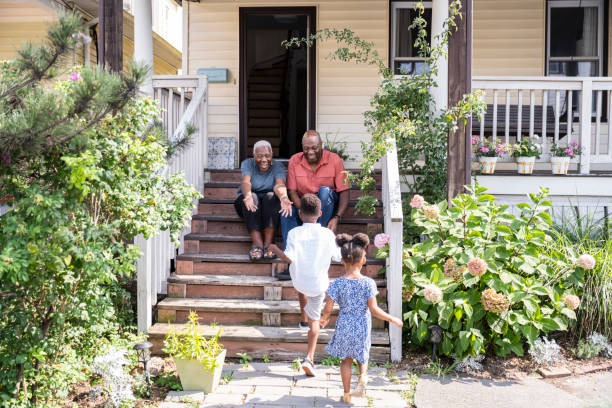 szczęśliwi czarnoskórzy seniorzy witają odwiedzające wnuki - arms outstretched greeting house women zdjęcia i obrazy z banku zdjęć