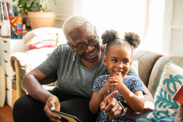 istock Cheerful Black senior and granddaughter using smart phone 1736962317