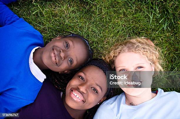 Three Happy Girls Caer En El Césped Foto de stock y más banco de imágenes de Chica adolescente - Chica adolescente, Retrato, Tres personas