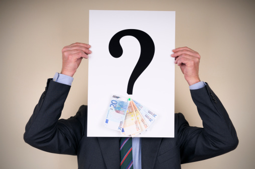 Businessman holding question mark with money in the bottom